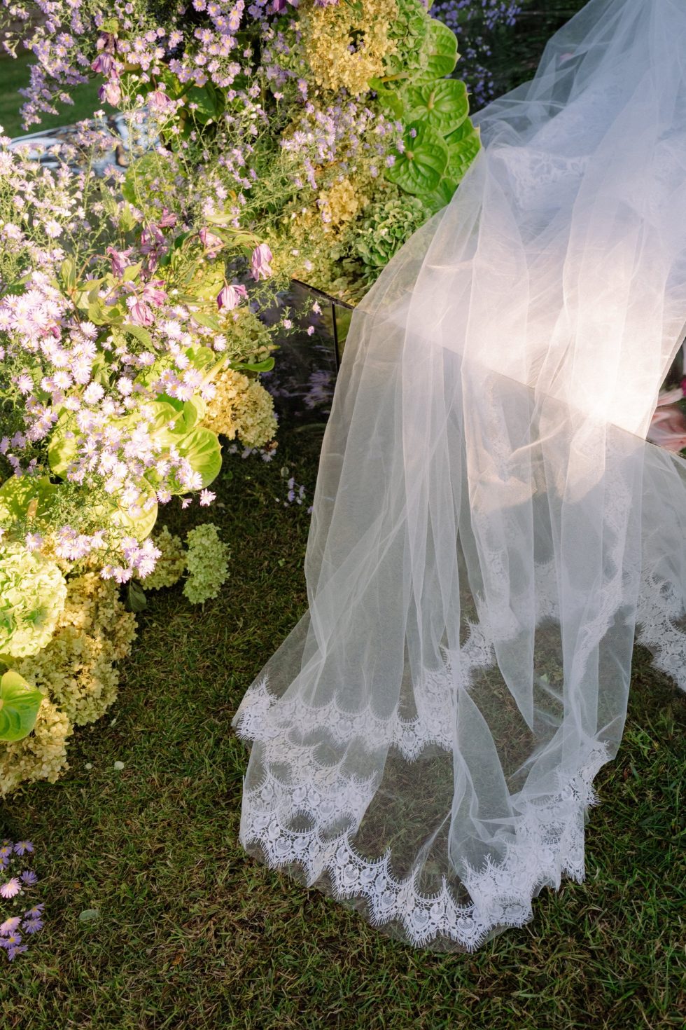 The bride's lace veil among the flowers of the ceremony at Castello Odescalchi