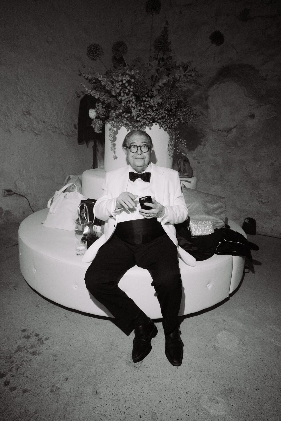 A guest relaxing on a white sofa at the wedding party, black and white, Castello Odescalchi
