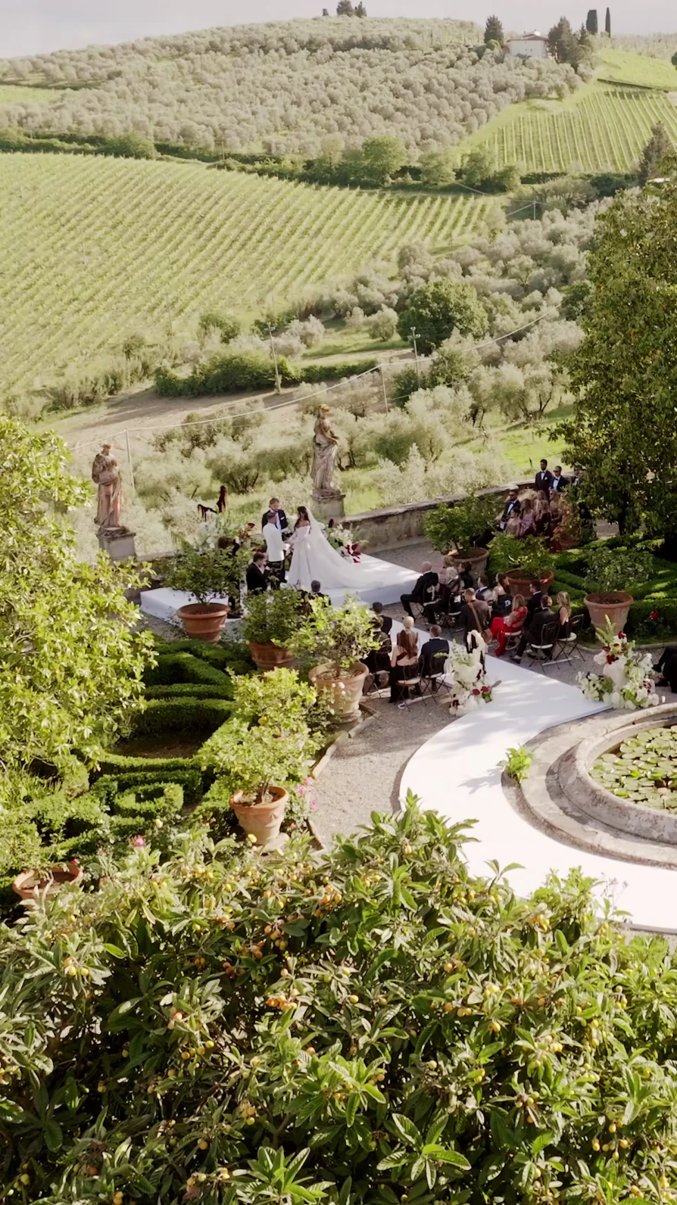 The wedding ceremony in the gardens of Villa Corsini, with vineyards and olive groves behind