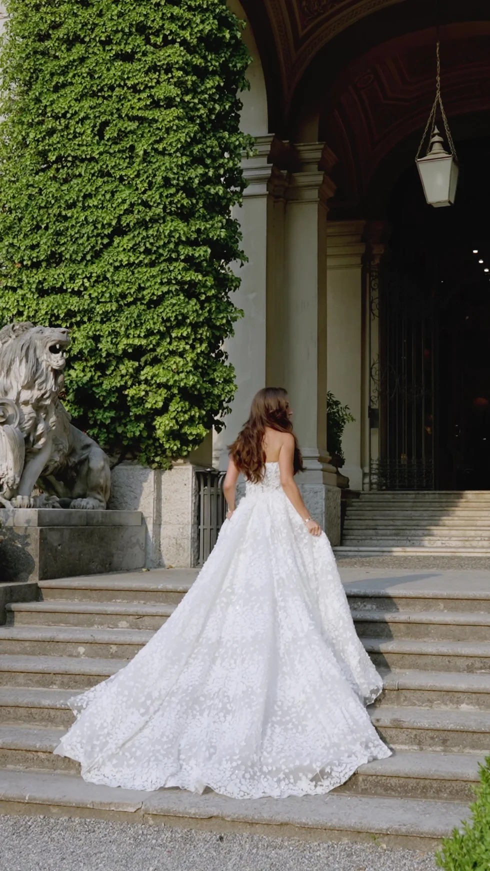 The bride walking up the steps of Villa Erba, seen from behind