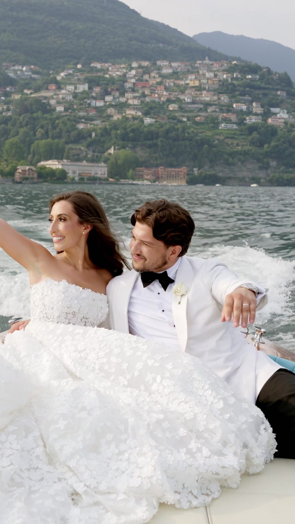 Renee and Tino laughing on a classic wooden boat on Lake Como