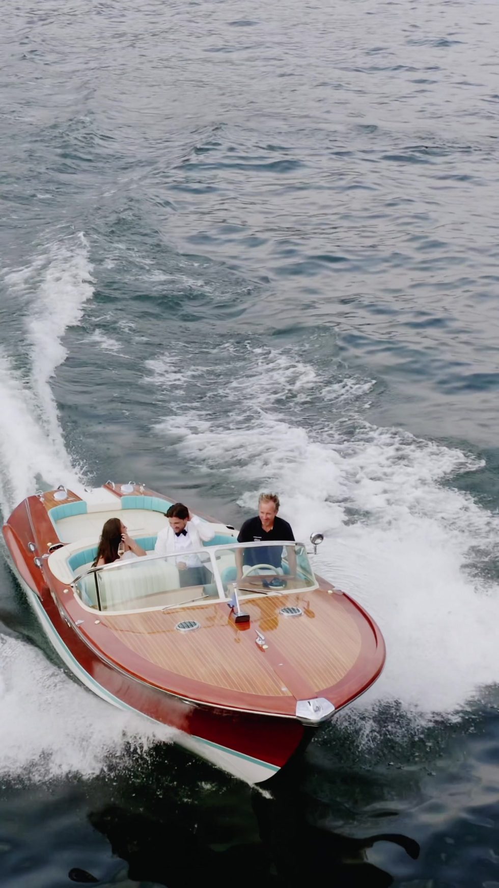 A classic wooden speedboat carving across Lake Como