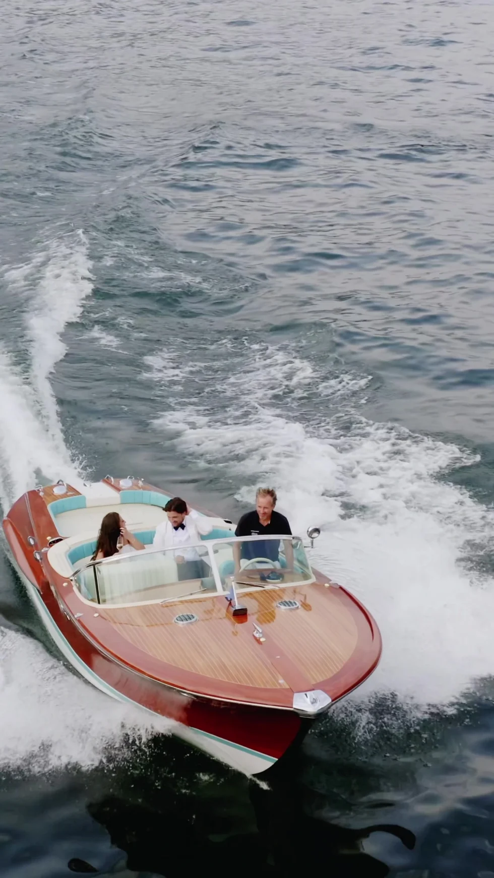 A classic wooden speedboat carving across Lake Como