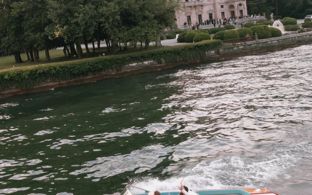 Newlyweds on a classic wooden speedboat cruising Lake Como near Villa Erba