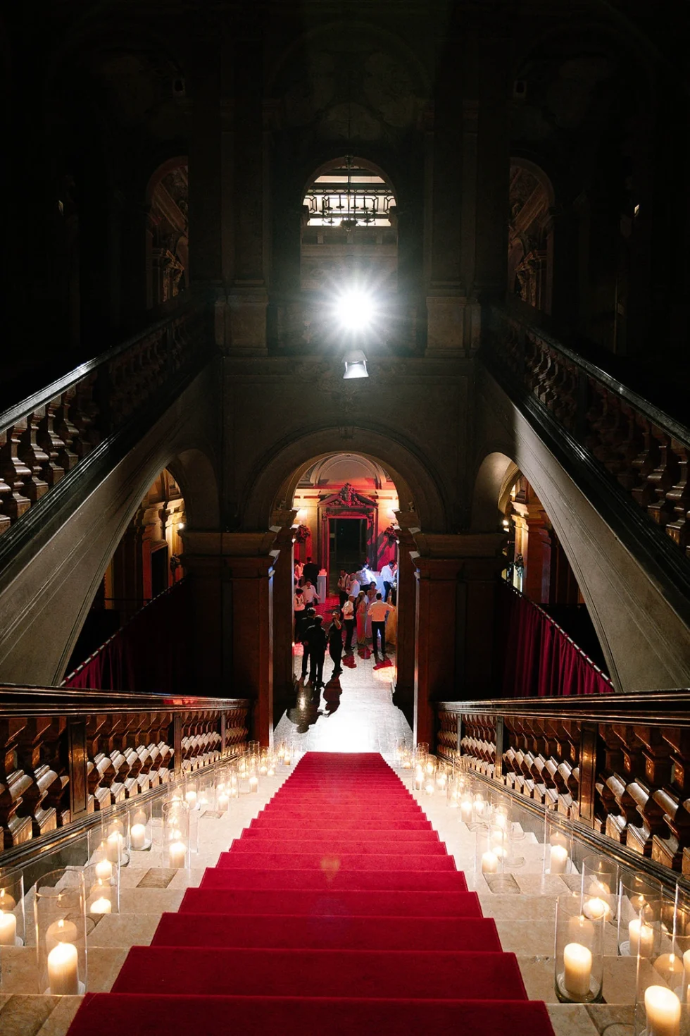 Candlelit red-carpet grand staircase of Villa Erba during the wedding reception