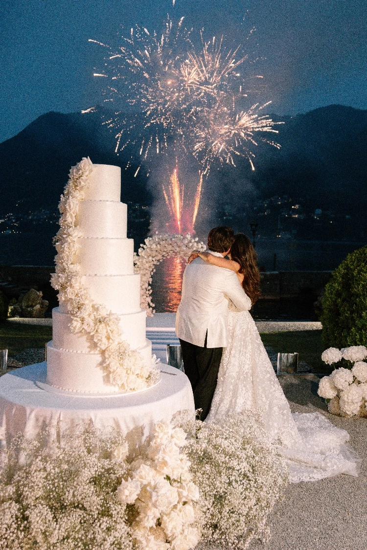 Renee and Tino watching the fireworks over Lake Como beside their wedding cake at Villa Erba