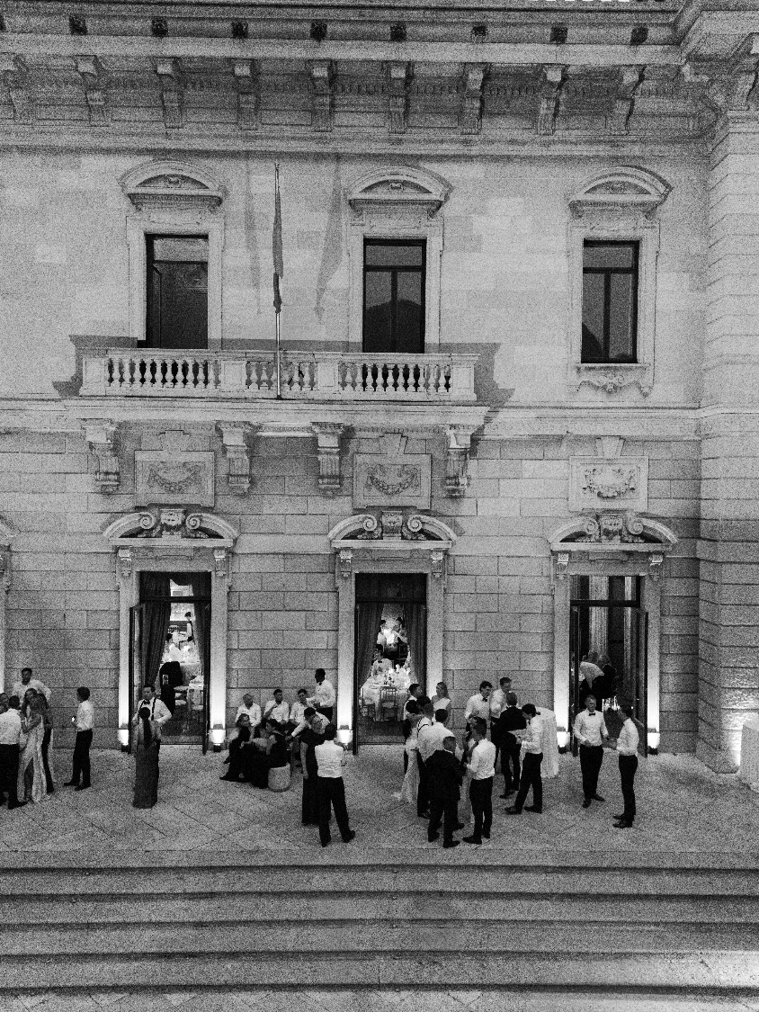 Wedding guests on the terrace of Villa Erba at night, in black and white