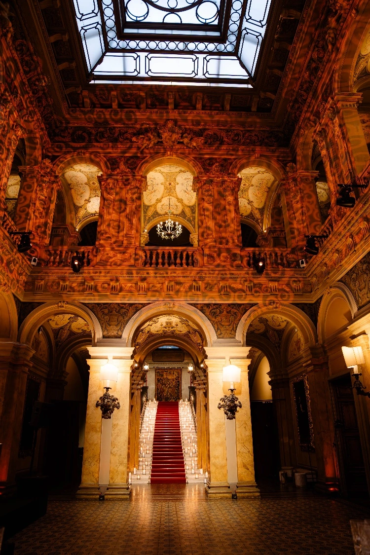 The grand hall and candlelit red staircase of Villa Erba, Cernobbio