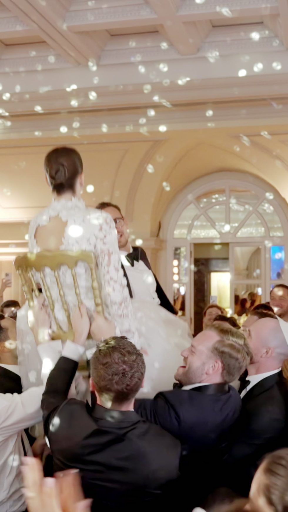 The bride lifted on a chair by the guests during the wedding party at Villa Miani