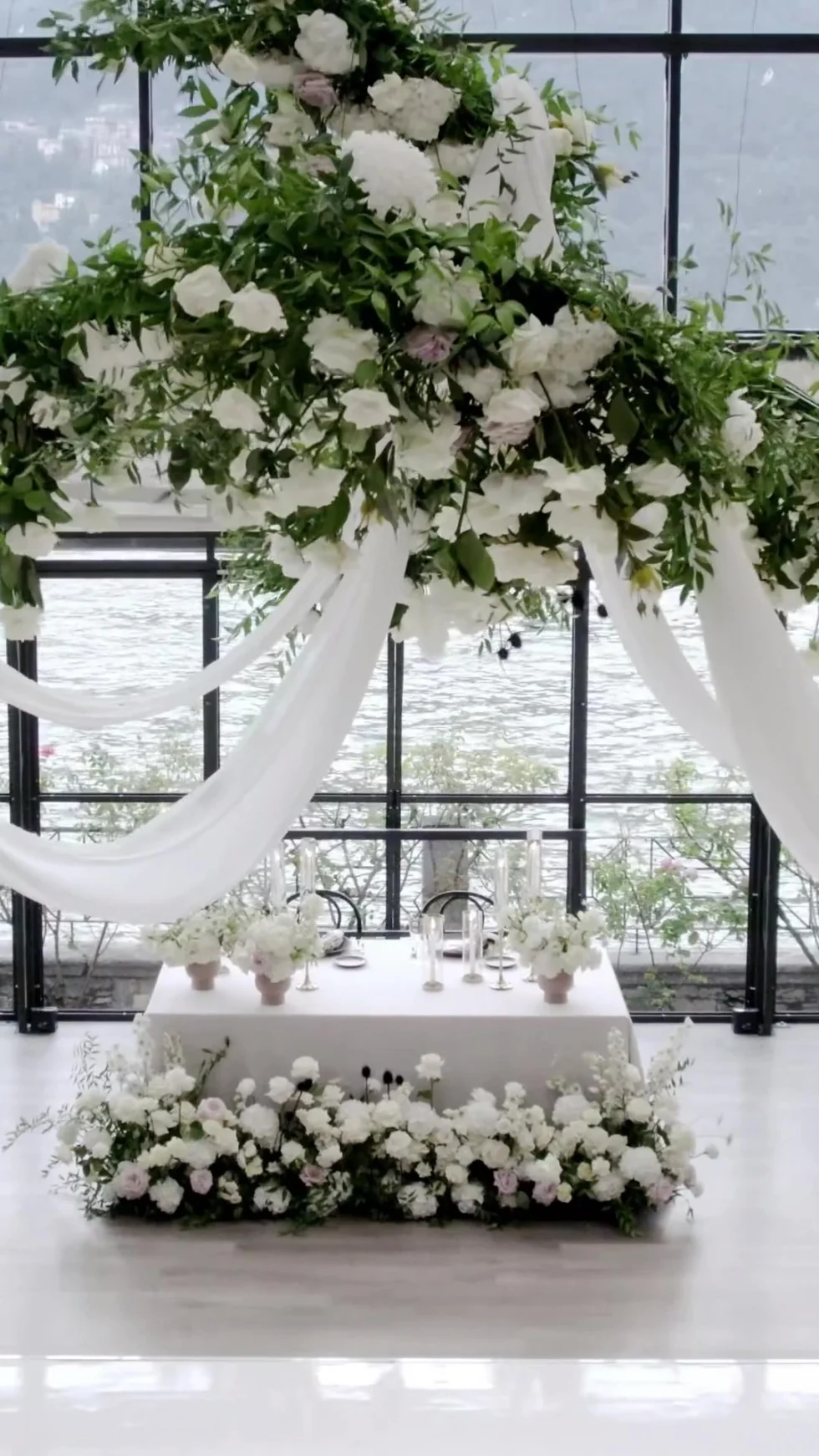 The floral sweetheart table under white drapery at Villa Pizzo