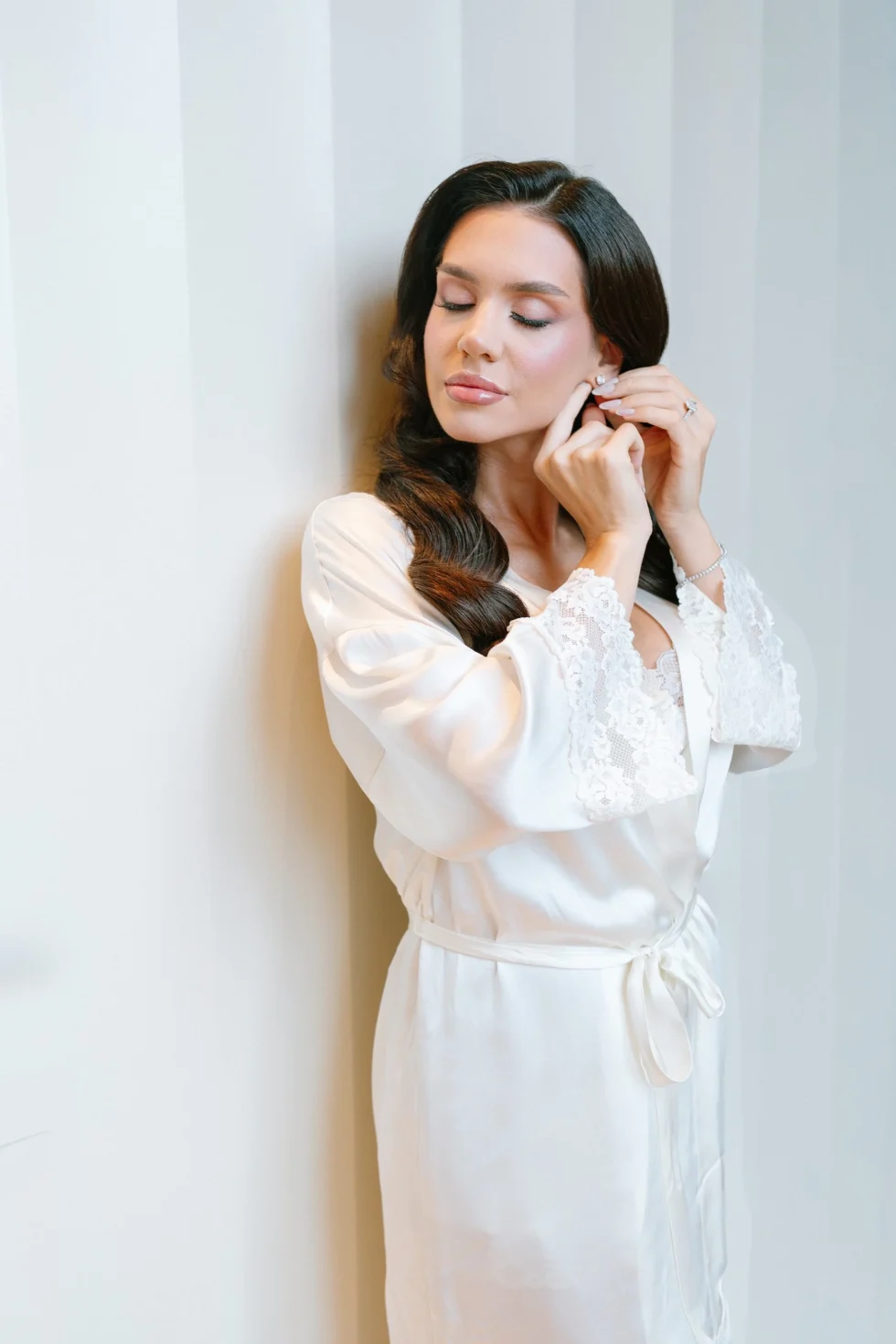 Tania putting on her earrings on the morning of her wedding at the Bulgari Hotel Roma