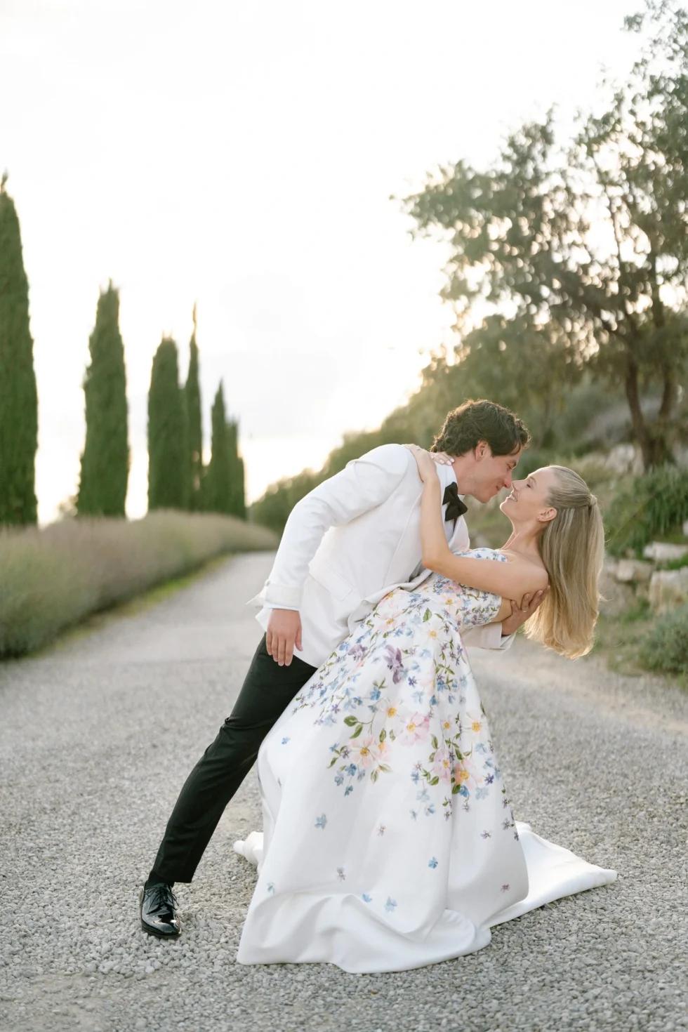 The couple kissing on a cypress-lined road in the Sienese countryside