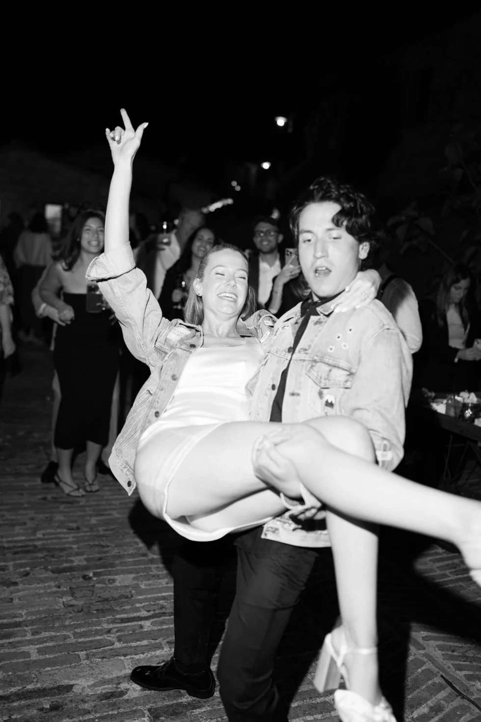 The bride lifted by a guest on the dance floor, black and white