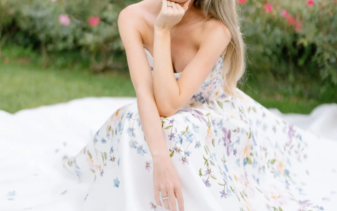 The bride crouching on the lawn in her floral gown among the roses at Borgo Vescine, near Siena – Wedding Photographer in Siena, Tuscany · Borgo Vescine