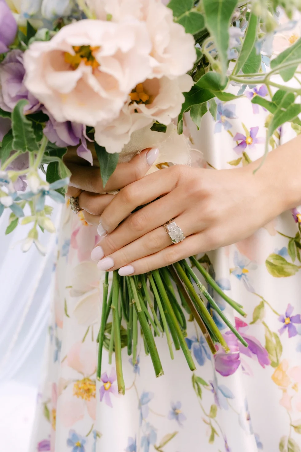 The bride's bouquet of garden roses against her floral gown
