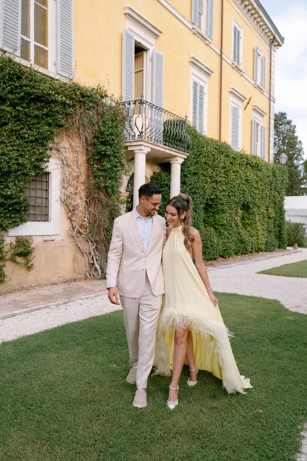 Hadi and Suzanne walking arm in arm across the lawn of Palazzo di Bagnaia, Umbria