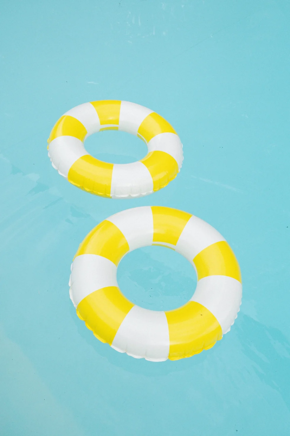 Yellow and white pool rings floating in the pool of Palazzo di Bagnaia, Umbria