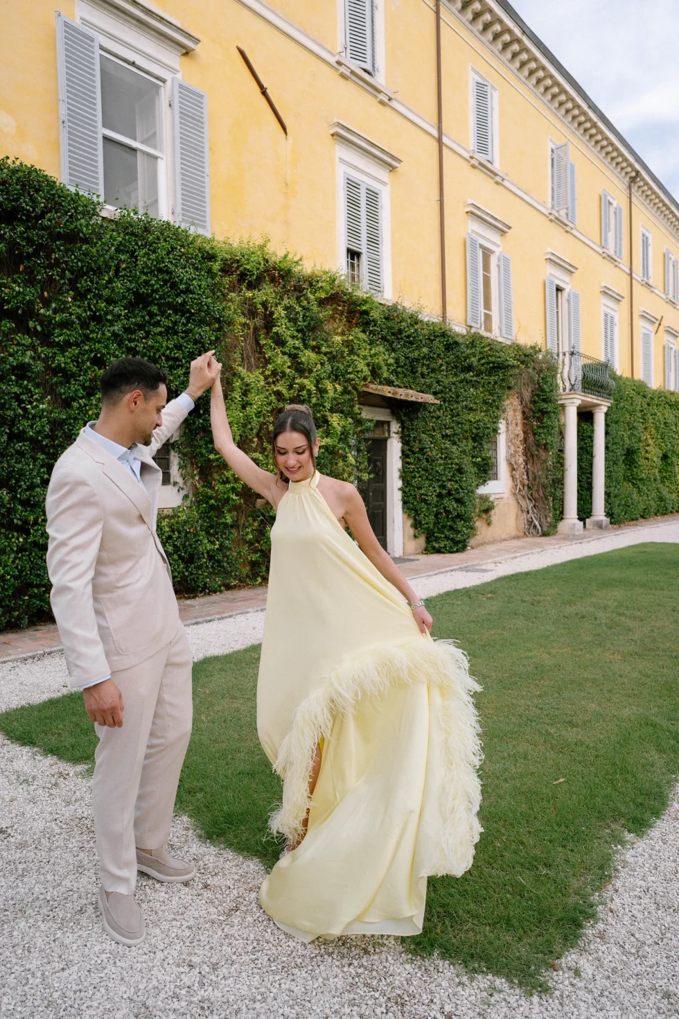 Hadi twirling Suzanne on the lawn of Palazzo di Bagnaia during their destination wedding in Umbria