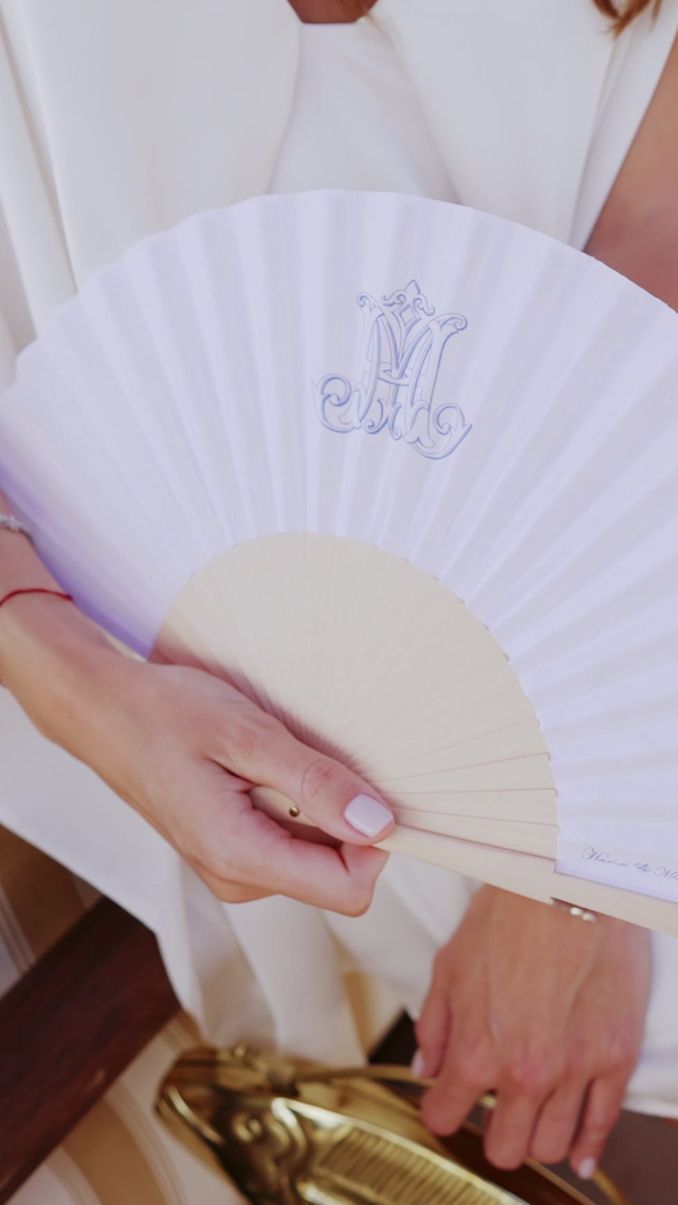 A hand fan with the couple's monogram at their wedding in Cannes