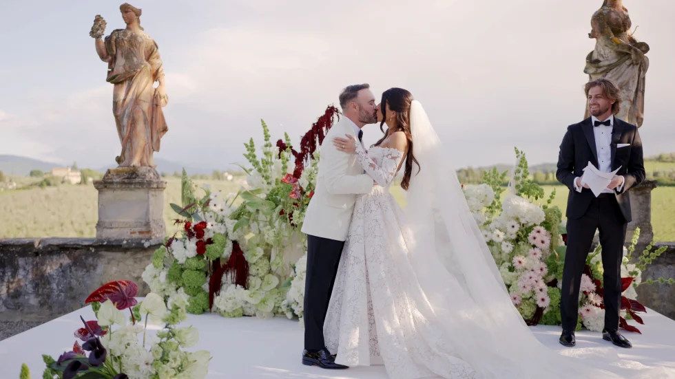 Jenna and Jameson kissing at the altar among the statues of Villa Corsini, with the Florentine hills behind