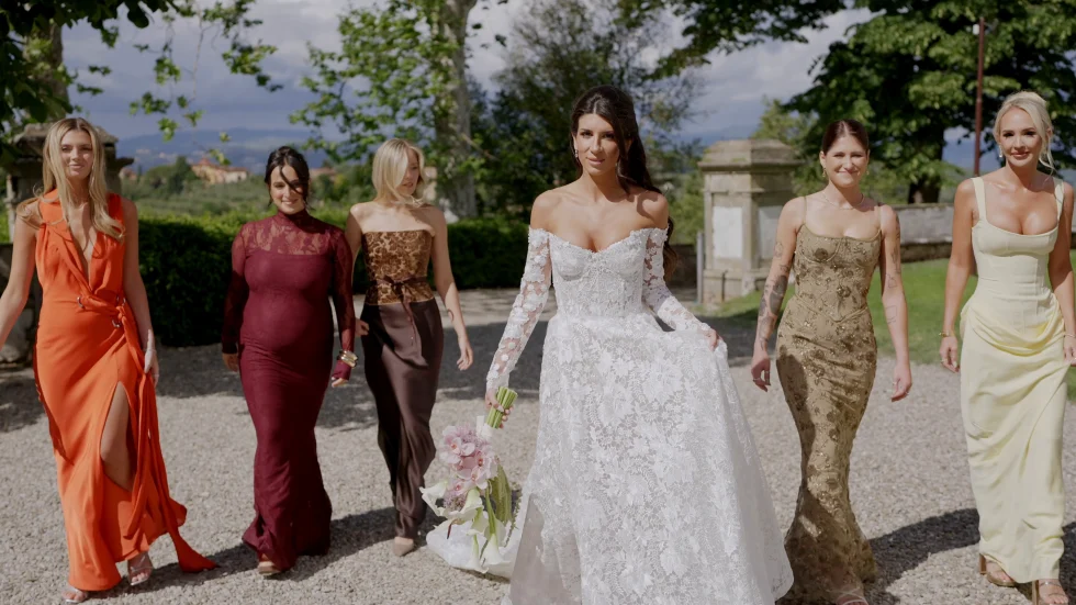 Jenna walking with her bridesmaids in jewel-toned gowns at Villa Corsini