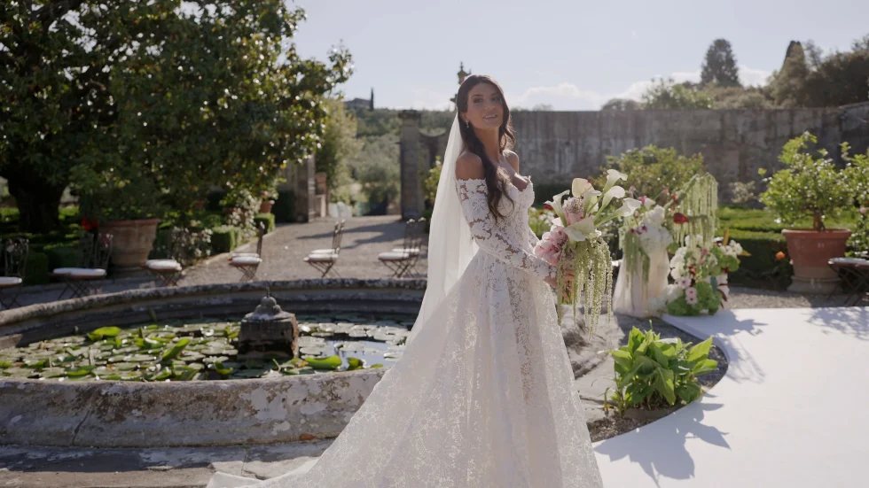 Jenna in her lace gown and veil by the fountain of the Italian garden at Villa Corsini