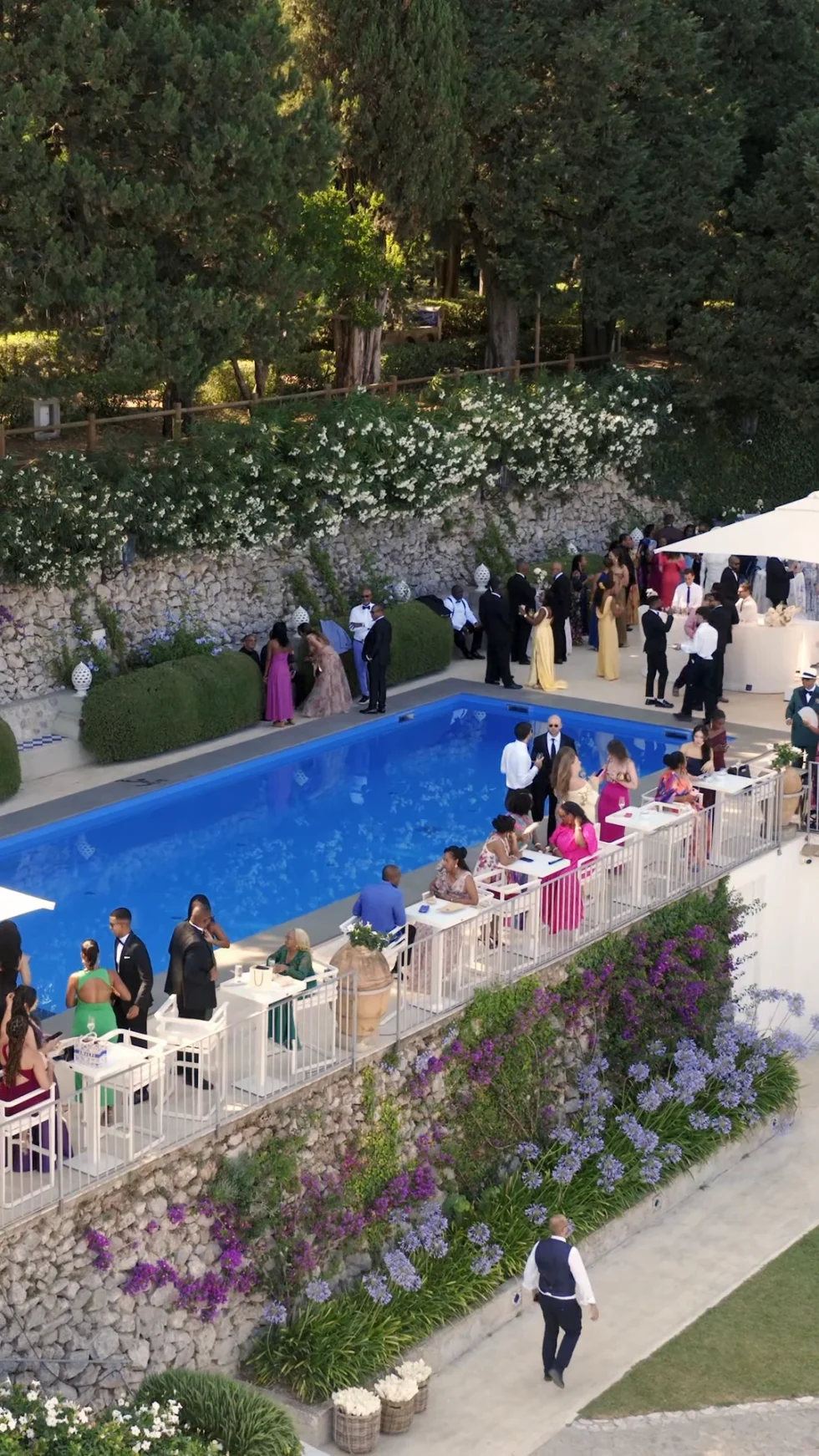 Guests at the cocktail hour by the pool of La Rondinaia, seen from above